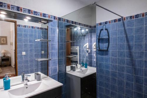 - une salle de bains carrelée de bleu avec deux lavabos et un miroir dans l'établissement Gite U fragnu di Peruccio, à Levie