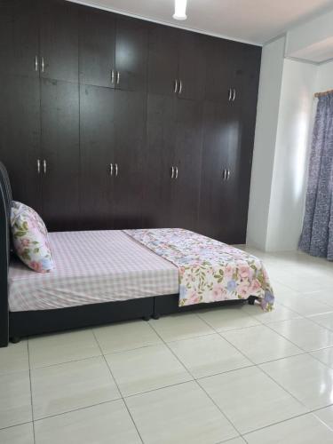 a bedroom with a bed with brown cabinets at Ssue Klebang Ipoh Homestay With Complementary Pool & High Speed internet WIFI in Chemor