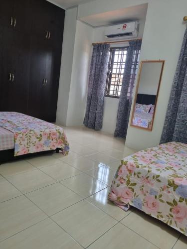 a bedroom with two beds and a mirror in it at Ssue Klebang Ipoh Homestay With Complementary Pool & High Speed internet WIFI in Chemor