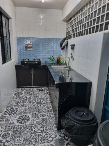 a kitchen with a sink and a tile floor at Ssue Klebang Ipoh Homestay With Complementary Pool & High Speed internet WIFI in Chemor