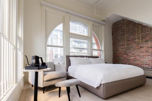 a bedroom with a large bed and a brick wall at Gladstone House in Toronto
