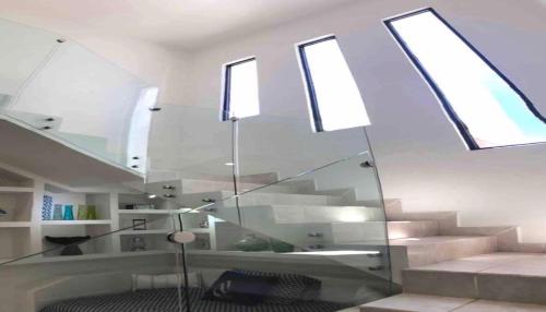Cette chambre est dotée d'un escalier en verre avec des lucarnes. dans l'établissement House In Miramar Seaview And Private Pool templada, à Guaymas