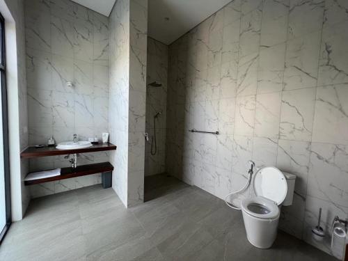 La salle de bains est pourvue de toilettes et d'un lavabo. dans l'établissement Villa Niang Ando, à Labuan Bajo