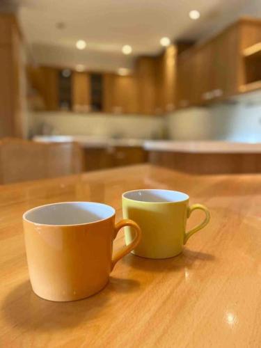two cups sitting on top of a wooden table at Zentrale Wohnung Gmunden Alte Bäckerei in Gmunden