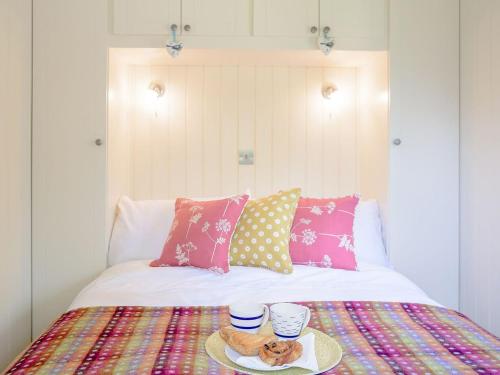a bed with a plate of food and two cups on it at Under Willows - Uk12608 in Burton Overy