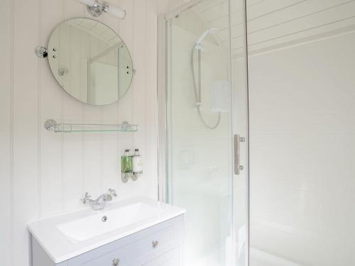 a white bathroom with a sink and a shower at Under Willows - Uk12608 in Burton Overy