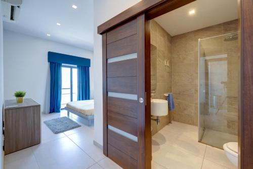 een badkamer met een douche, een toilet en een glazen deur bij Seaview Apartment Top Location in Sliema in Sliema