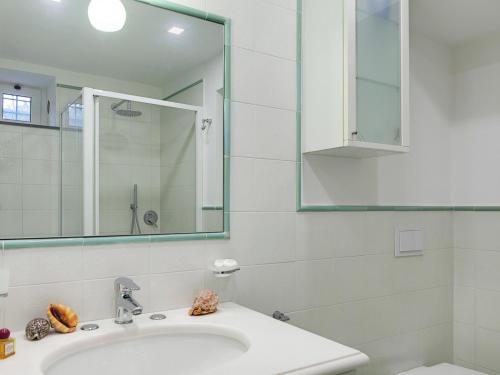 La salle de bains blanche est pourvue d'un lavabo et d'un miroir. dans l'établissement Casa Giuseppe by Gocce, à Sant'Agnello