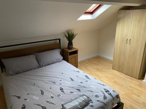 een slaapkamer met een bed en een dakraam bij The Vacationers - Pvt Rooms with Shared Bath in Sunderland