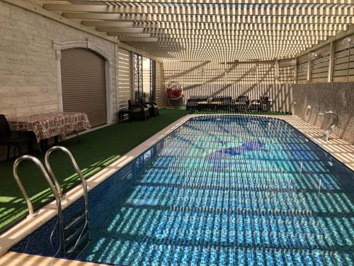 uma grande piscina com água azul num edifício em Old Jericho homestay em Jericó
