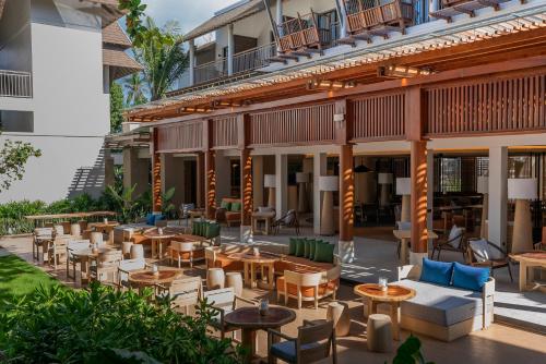 an outdoor patio of a hotel with tables and chairs at Holiday Inn Resort Samui Bophut Beach by IHG in Bophut 