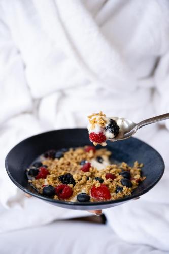 a spoon with a piece of granola and berries at Gladstone House in Toronto