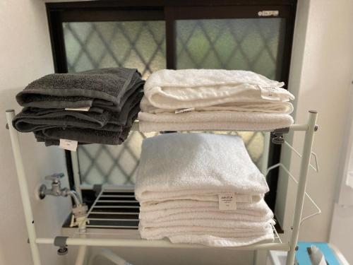 a stack of towels on a rack in a bathroom at 秩父 思源屋 