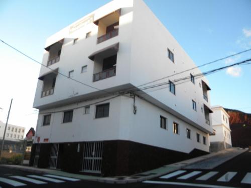 a white building on the side of a street at Apartamentos Restinga in La Restinga