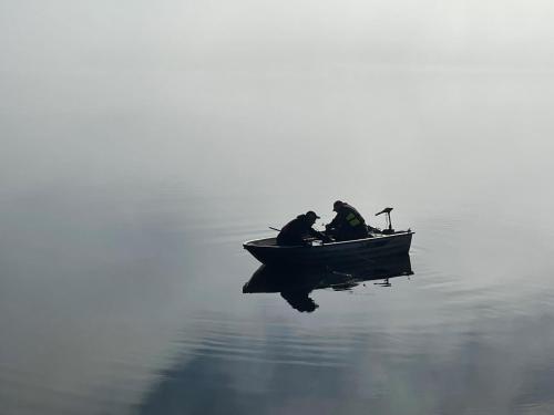 three people sitting in a boat on the water at Tärnaby Rooms & Apartments in Tärnaby