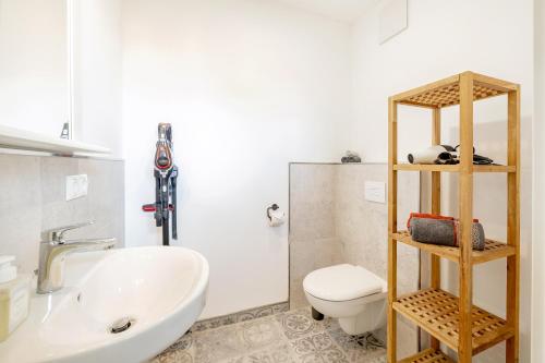 a bathroom with a white sink and a toilet at Güterloft Altefähr in Altefähr