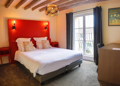 een slaapkamer met een groot bed met een rood hoofdeinde bij Ferme du Roy in Anserville