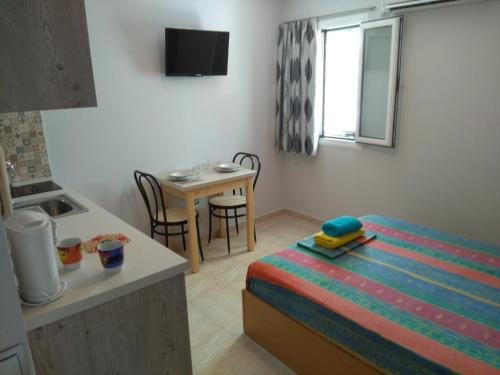 Habitación pequeña con cama y mesa pequeña. en Town Apartment & Studio en Argostoli