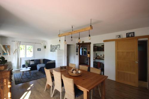 uma sala de estar com uma mesa de madeira e cadeiras em Les chambres de Sophie em Chalabre