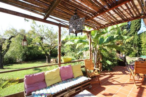 a couch on a patio under a wooden pergola at Les chambres de Sophie in Chalabre