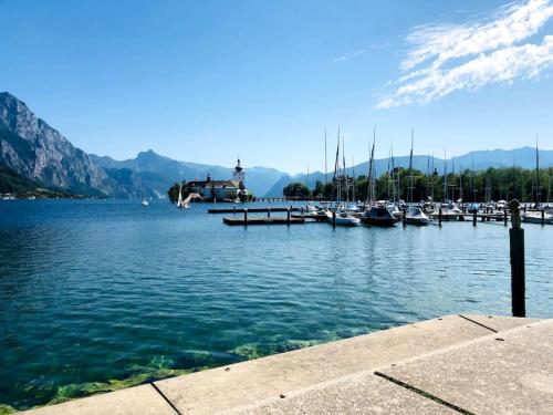 a marina with boats in the water and mountains at Fewo Kuferzeile Gmunden seenähe in Gmunden