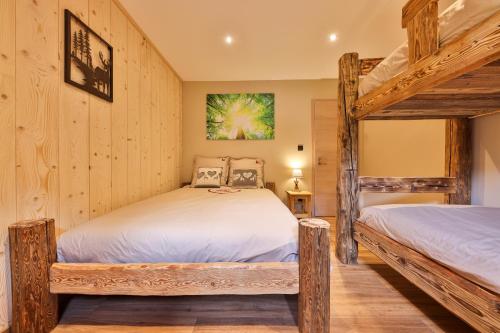 two bunk beds in a room with wooden walls at Le Refuge du Bûcheron in Mittlach