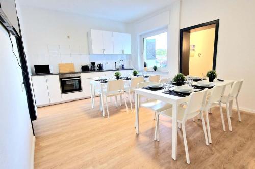 una sala da pranzo con tavoli e sedie bianchi in cucina di Duplex Apartment with Roof-Top -MND01- 