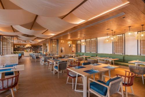 a restaurant with wooden ceilings and tables and chairs at Holiday Inn Resort Samui Bophut Beach by IHG in Bophut 