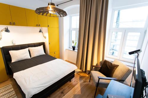 1 dormitorio con 1 cama, 1 silla y TV en Stilvolle Wohnung mit ruhig gelegenem Balkon, en Viena