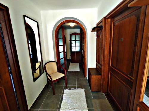 a hallway with a door and a chair in a room at Alea Apartmanok in Harkány