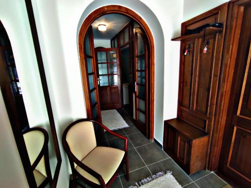 a hallway with a chair and a mirror at Alea Apartmanok in Harkány