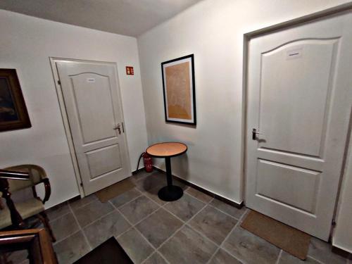 a room with two white doors and a small table at Alea Apartmanok in Harkány