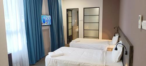 een ziekenhuiskamer met 2 bedden en een spiegel bij Roxy Hotel Sri Aman in Simanggang