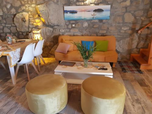 a living room with a couch and a table at Old House Villa Moudros- Kaminia Lemnos Λήμνοs in Ayía Sofía