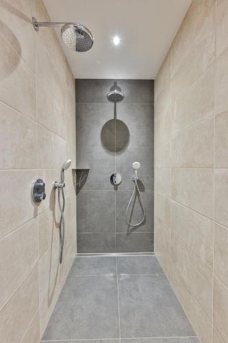 une salle de bain avec une douche avec une porte vitrée dans l'établissement Le Refuge du Bûcheron, à Mittlach