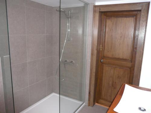 una doccia con porta in vetro in bagno di Gite des Comagnes a Limbourg
