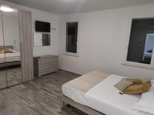 Habitación blanca con cama y espejo en Ca Rossa, en Bondeno