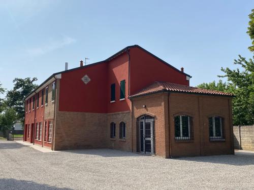a red building sitting on the side of a road at Ca Rossa in Bondeno