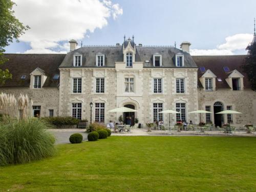 duży kamienny dom z zielonym trawnikiem w obiekcie Chateau De Fere w mieście Fère-en-Tardenois