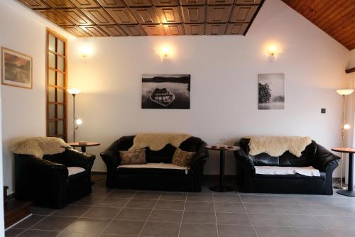 a living room with two couches and two tables at Alea Apartmanok in Harkány