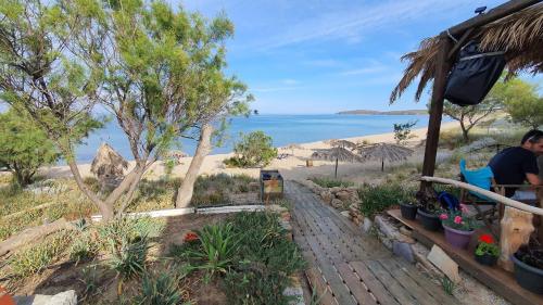 a man sitting at a table near the beach at Old House Villa Moudros- Kaminia Lemnos Λήμνοs in Ayía Sofía