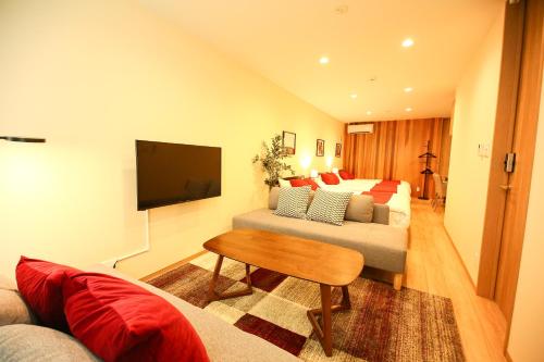 a bedroom with a bed and a tv and a couch at PrimeRoom別府 浜脇温泉前 in Beppu