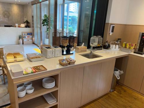 a kitchen with a sink and a counter with food at Bonatree Hotel in Busan