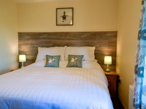 a bedroom with a white bed with two pillows at Olivia - Uk13137 in Barnby Moor