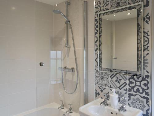 a bathroom with a shower and a sink and a mirror at Olivia - Uk13137 in Barnby Moor