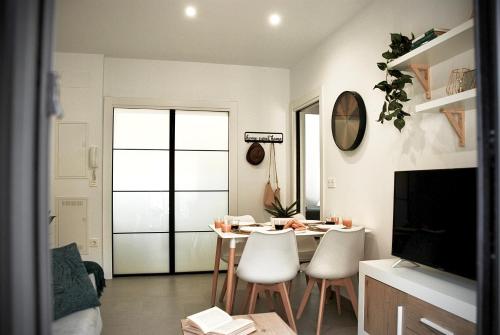 a living room with a dining room table and chairs at SANTA MARÍA APARTMENT Precioso apartamento en el centro de Granada - Parking gratuito in Granada