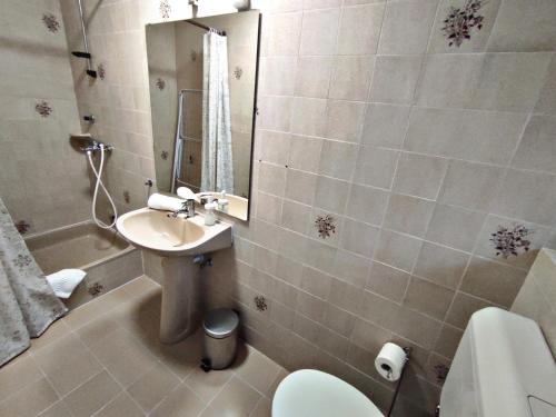 a bathroom with a sink and a toilet and a mirror at Alea Apartmanok in Harkány