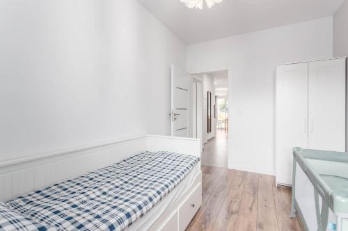 a white bedroom with a bed and a bathroom at Enjoy! Ursus in Warsaw