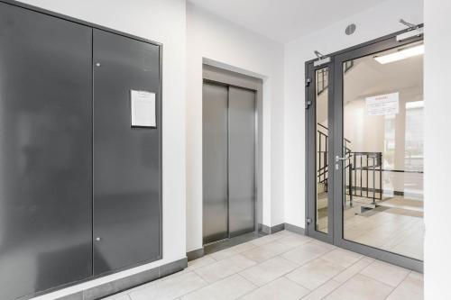 a pair of glass elevator doors in a building at Enjoy! Ursus in Warsaw