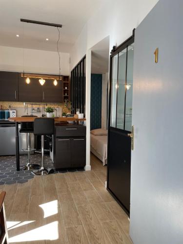 - une cuisine et un salon avec une table et un comptoir dans l'établissement Le Studio Cosy, à Orléans